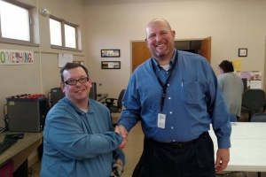 Volunteer shaking hands with adult male