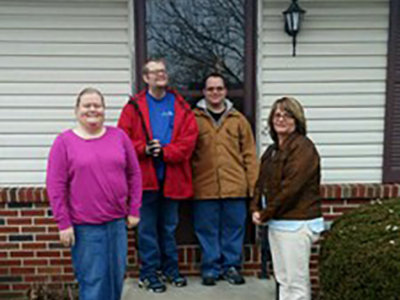 group of adults standing in front of door