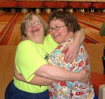 Two women hugging at the bowling alley